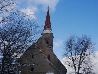 Blick auf die St Bartholomäuskirche leicht mit Schnee bedeckt an einem sonnigen Wintertag